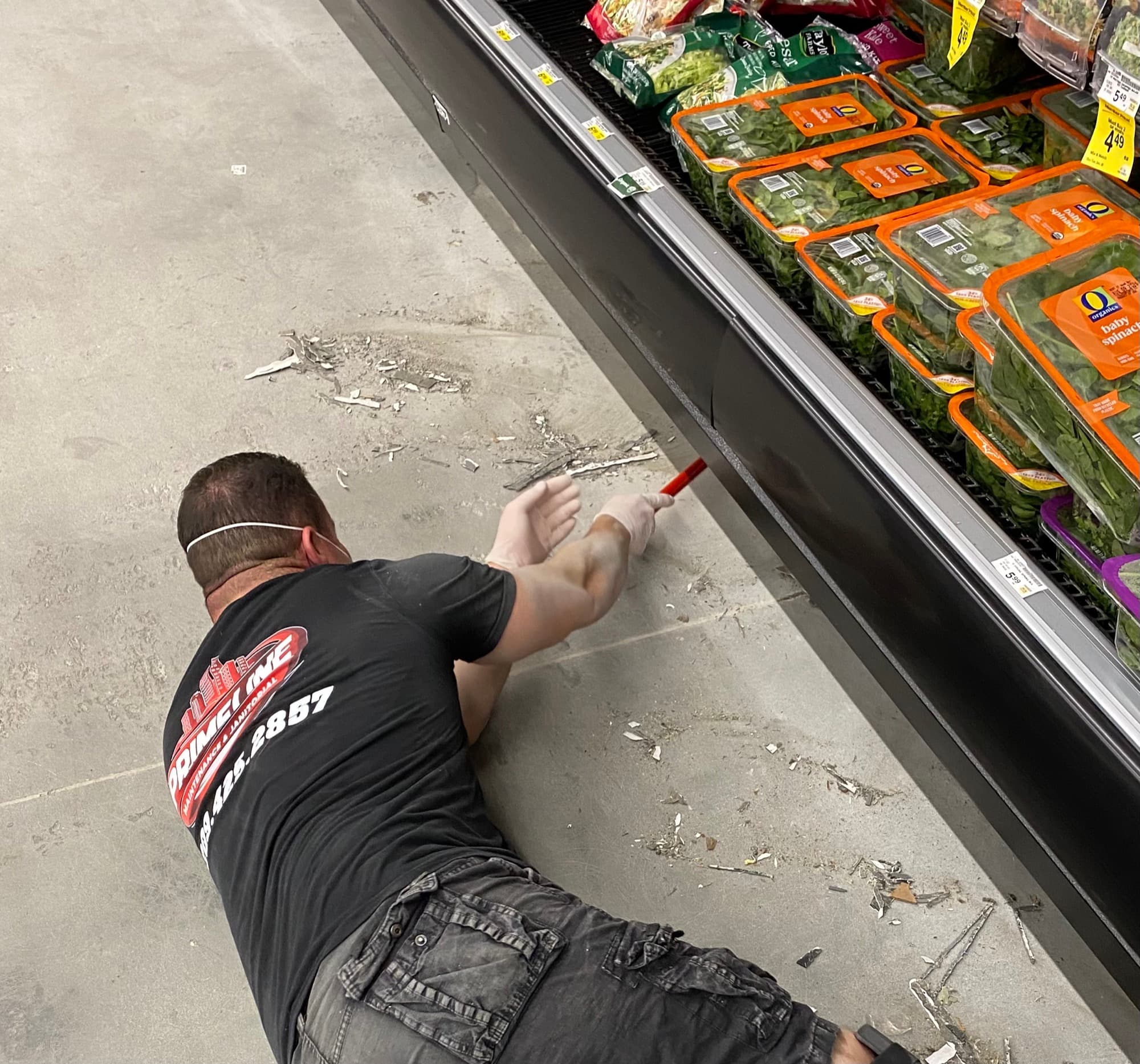 Primeline Maintenance & Janitorial crew member detailing a produce cooler shelf